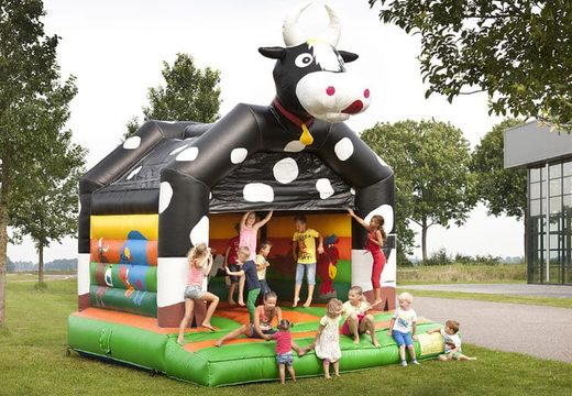 Standard bouncy castle for sale in striking colors with a large 3D object of a cow on top, for children. Buy indoor bouncy castle online at JB Inflatables UK