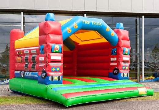 Big super bounce house covered with cheerful animations in fire department theme for children. Order bounce houses online at JB Inflatables UK