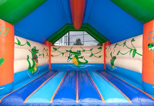 Big super bounce house covered with cheerful animations in crocodile theme for children. Order bounce houses online at JB Inflatables UK