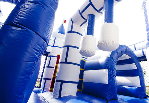 Multiplay blue and white castle bounce house with a slide and fun objects on the jumping surface for kids. Order inflatable bounce houses online at JB Inflatables UK