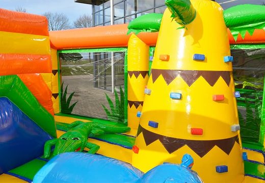 Buy a large Indoor Jungle bouncy castle with a slide on the jumping surface, climbing tower and fun obstacles with jungle themed prints for kids. Order bouncy castles online at JB Inflatables UK.