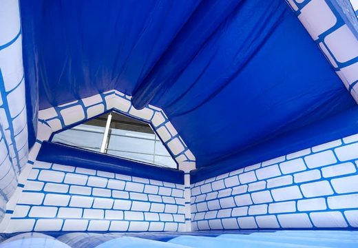 Large covered blue white bouncy castle in castle theme for sale for children. Order bounce houses online at JB Inflatables UK